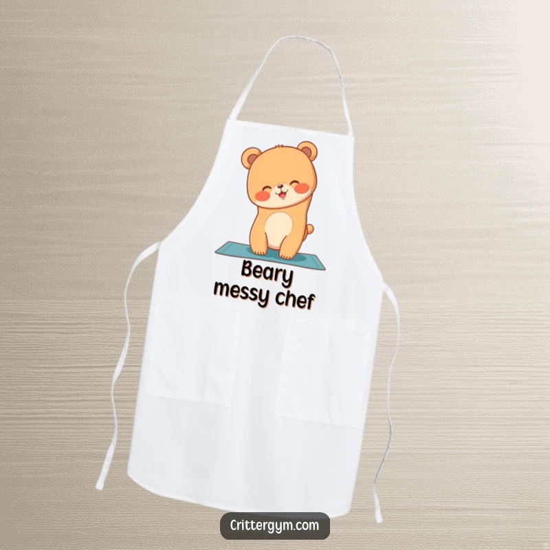 Funny apron showing a giggling bear cub attempting a yoga handstand on a mat while cooking with humor.