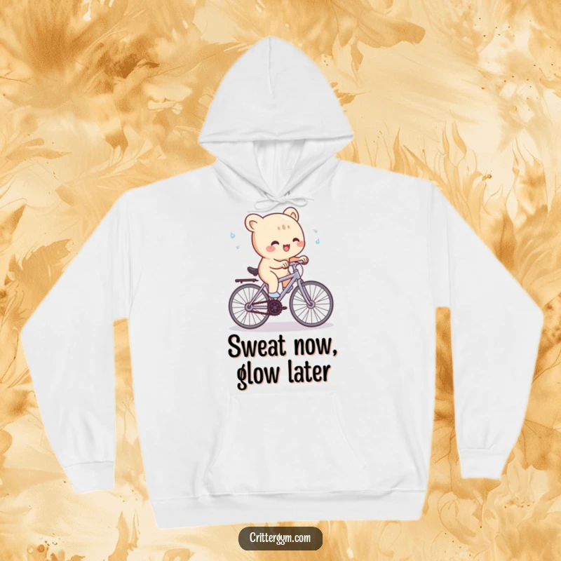 Funny Hoodie: A cute creature gleefully pedals a minuscule stationary bicycle, with sweat flying, depicting humorous cycling intensity.
