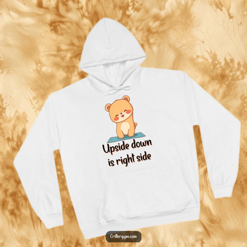 Funny bear cub doing a handstand on a yoga mat, featured on a cozy hoodie, ideal for a funny gift.